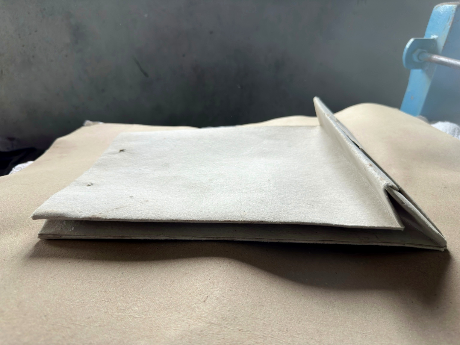 Close detail of a folded handmade paper sheet showing its soft deckle edge